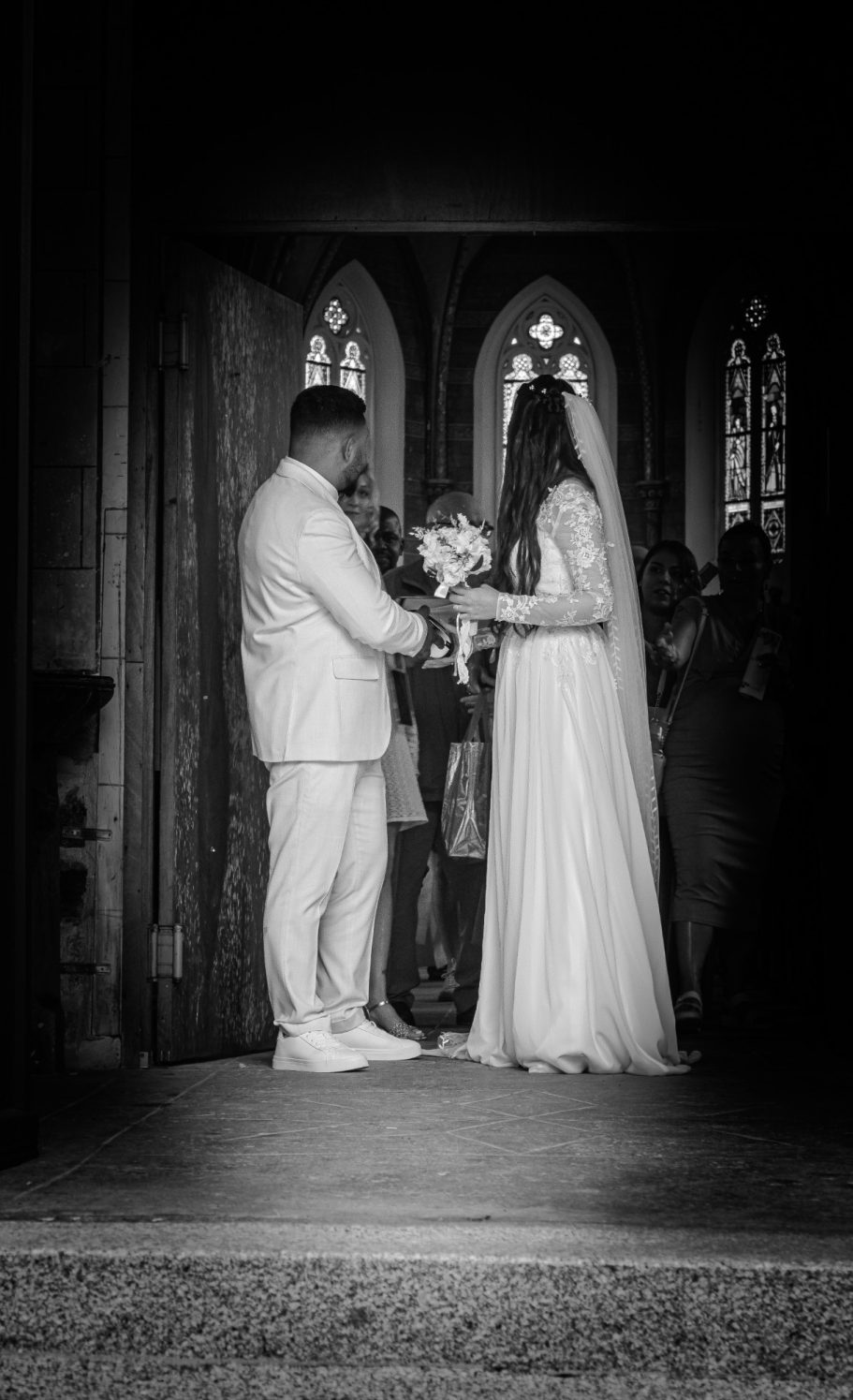 Mariage dans une église, couple en tenue nuptiale échangeant des vœux.