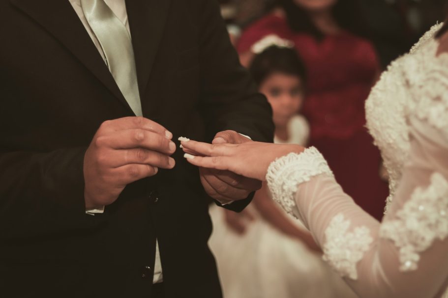 Un homme met une alliance au doigt d'une femme lors d'une cérémonie de mariage.